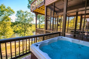 A hot tub on a wooden deck with a view of a river and trees. - Eagle's Nest- A pet friendly cabin on the river! (Luray)