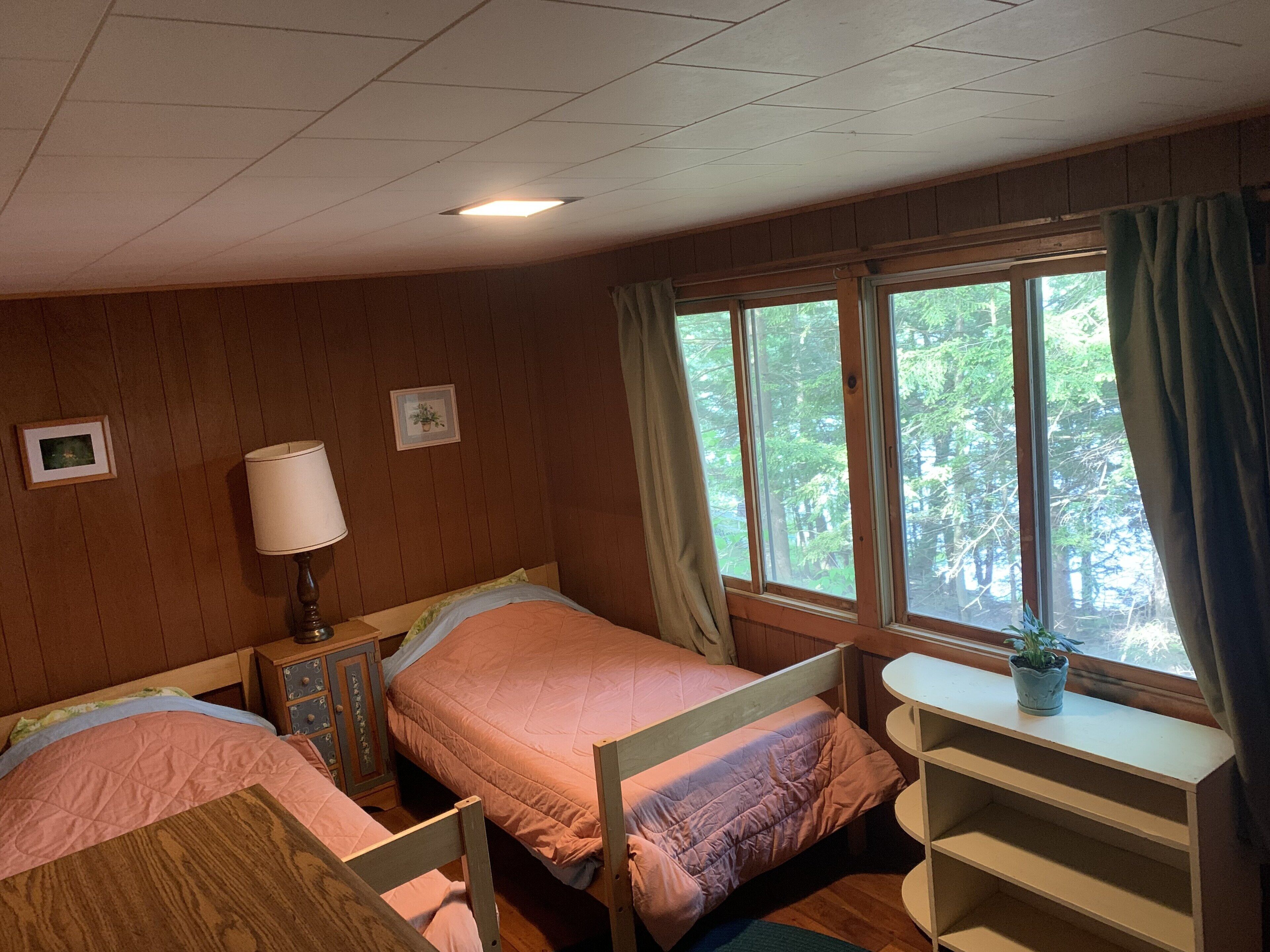 The twin bedroom looks out onto the woods and the lake.
