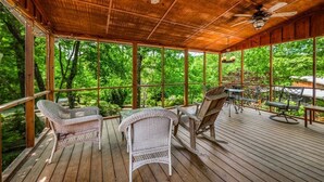Eine überdachte Terrasse mit Korbmöbeln und Deckenventilator.