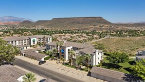 A residential area with modern buildings, a large hill in the background, and a clear sky. - Las Palmas! Beds for 9-10! 3Bed 2Bath, Bunks for kids! Huge deck! (St George)