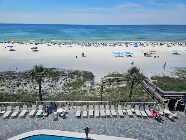 A beach resort with a pool area, lounge chairs, and umbrellas. - Beautiful Ocean Front Condo in Orange Beach....Affordable Prices (Orange Beach)