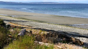 En strand med en klippefyldt kystlinje og udsigt over havet.