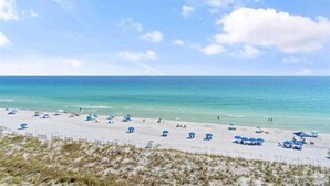 A beach with white sand, clear blue water, and a few umbrellas. - Multi-Family, sleeps 12, GULF FRONT with BEACH VIEWS FROM EVERY ROOM (Pensacola Beach)