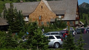 A large wooden building with a steeply pitched roof, surrounded by trees and parked cars. - Private 5 Acres in Packwood, close to Cowlitz River, Mt. Rainer & White Pass. (Packwood)