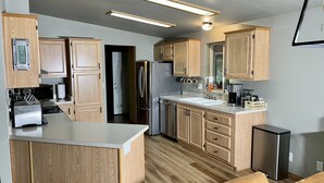 A modern kitchen with wooden cabinets, stainless steel appliances, and a built-in oven. - Private 5 Acres in Packwood, close to Cowlitz River, Mt. Rainer & White Pass. (Packwood)