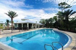 Piscina com área coberta e palmeiras.