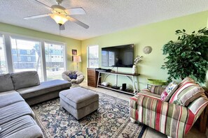 Relax in this inviting living room with a sectional sofa, armchair, and ottoman, perfect for unwinding.