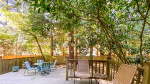 A wooden deck with outdoor furniture, surrounded by trees and a wooden fence. -  Foodies Kitchen, Peaceful, Green, Comfiest Beds, Close to everything   (Olympia)