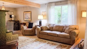 A living room with a sofa, armchair, and a wooden cabinet. -  Foodies Kitchen, Peaceful, Green, Comfiest Beds, Close to everything   (Olympia)