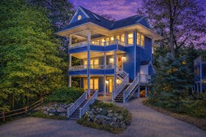 A multi-story house with a balcony, a staircase, and a driveway. - Luxury Macatawa Beach Home with Stunning Lake Michigan Views (Holland)