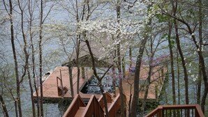 Una terraza de madera con escaleras que llevan a una casa junto al lago.
