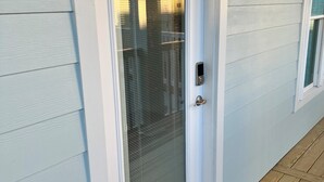 A white door with a glass panel and a metal handle. - Rest, Relax & Enjoy Your Stunning Water Views in the Heart of Southport, NC! (Southport)