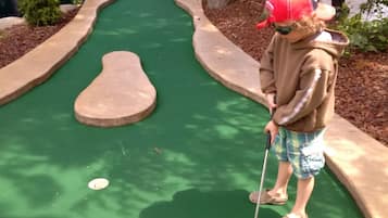 Play a round of golf amidst lush landscaping and obstacles.