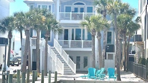 A two-story beachfront house with a balcony, palm trees, and outdoor seating. - Navarre Beach Southside bring your boat and jet skis huge private pier (Navarre)