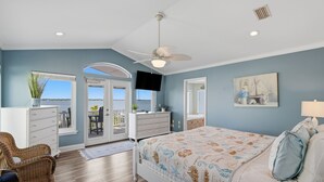 A bedroom with a bed, a ceiling fan, a dresser, a television, and a window with a view. - Navarre Beach Southside bring your boat and jet skis huge private pier (Navarre)