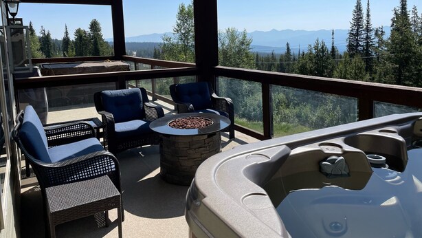 Ein Balkon mit Korbmöbeln, einem Steinkamin und einem Whirlpool.