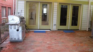 A brick patio with a grill and a door to a building. - 5 BR 4 BA New House- 1 Block to Library of Congress -Free Parking Permit (Washington)