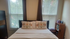 A bedroom with a bed, two windows with blinds, a bedside table, and a nightstand. - 5 BR 4 BA New House- 1 Block to Library of Congress -Free Parking Permit (Washington)
