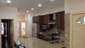 A kitchen with granite countertops, stainless steel appliances, and wooden cabinets. - 5 BR 4 BA New House- 1 Block to Library of Congress -Free Parking Permit (Washington)