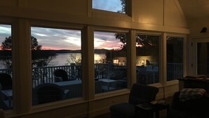 A room with large windows overlooking a lake at sunset. - Perfect Location For Your Lake Getaway (Cadiz)