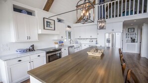 A spacious kitchen with white cabinetry, a wooden island, and a stainless steel refrigerator. - Perfect Location For Your Lake Getaway (Cadiz)