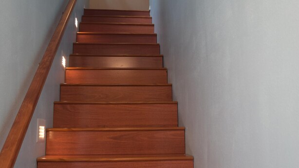 A wooden staircase with a handrail, leading to a landing with a light fixture. - Park like setting, brand new built, 1 bedroom ADU (Shoreline)