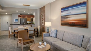 A modern hotel room with a sofa, armchairs, a dining table, and a kitchen area. - Confirmed Reservation - March 13–20, 2027 - 1BR Premium Villa - Instant Book (Scottsdale)