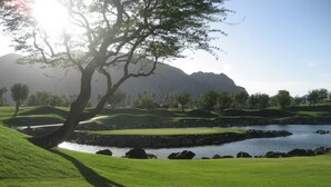 A golf course with a water body, trees, and a mountain in the background. - Charming and Contemporary 5 Star PGA West Condo Stadium on11th Tee Box Lic100888 (La Quinta)