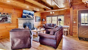 L’intérieur d’un chalet confortable, avec une cheminée, des meubles en cuir et des murs en bois.