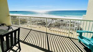 A balcony with a view of a beach and ocean.