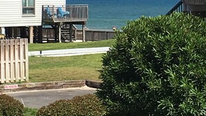 Zona residencial costera con una casa blanca que tiene un balcón con vistas al mar.