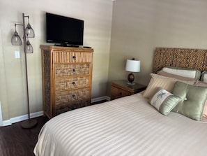 Une chambre d’hôtel avec un lit, une télévision, une lampe et une table de chevet.