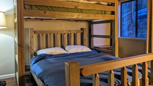 A bunk bed with a wooden headboard and a window with a view of trees. - [Skislope Cabin] Hot Tub - Dog Friendly (Truckee)