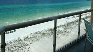 A balcony with a view of a beach and ocean. - Guests Rate Us Exceptional: Beach chairs  & umbrellas available for rent. (Pensacola Beach)