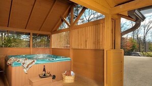 A wooden hot tub with steps leading up to it, a bottle, and a basket on the floor. - Misty Mornings: Rustic Resort Cabin - Pet Friendly - New Hot Tub (Sevierville)