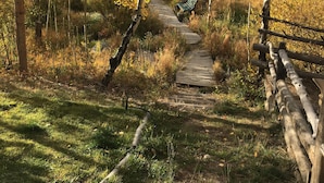A wooden boardwalk leading through a forested area with a bench at the end. - Beautiful cabin in aspen forest, amazing deck, lake and mountain views, private (Grand Lake)