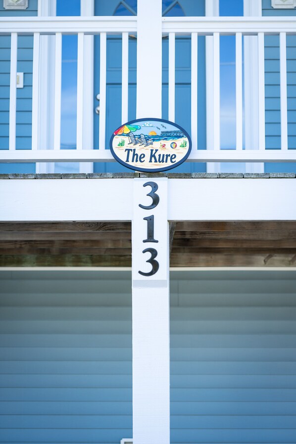 Uma casa com varanda e um letreiro que diz 'The Kure 313'.