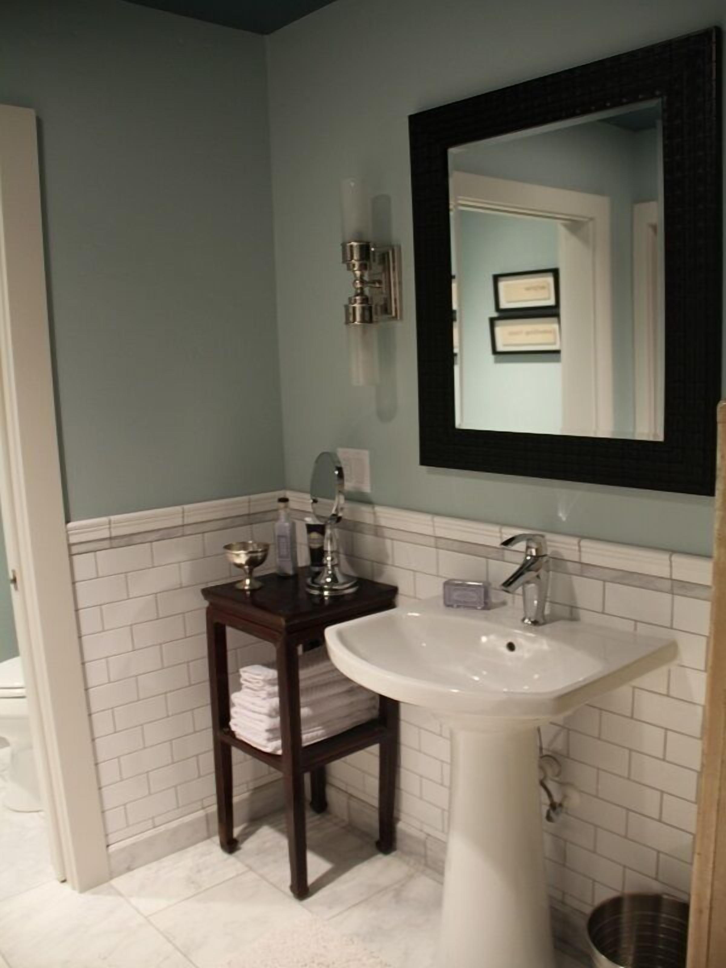 Une salle de bain avec un lavabo blanc, un meuble-lavabo en bois foncé et un miroir au-dessus du lavabo.