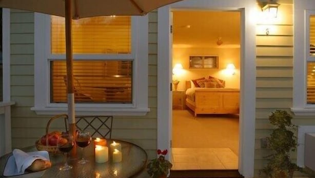 An outdoor seating area with a table, candles, and a potted plant. - Comfort and Style in Our Queen Cottage (Calistoga)