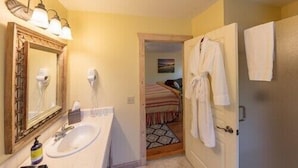 A hotel bathroom with a sink, mirror, and towel rack. - Comfort and Style in Our Queen Cottage (Calistoga)