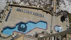 Ein Pool auf dem Dach mit einzigartigem Design, umgeben von Liegestühlen und einer Treppe zu einer oberen Ebene.