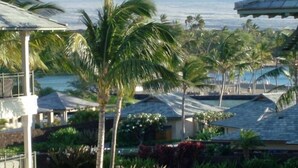 A resort with multiple buildings, palm trees, and a view of the ocean.