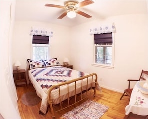 Classic bedroom with a single bed, nightstand, and ceiling fan.