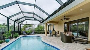 Piscina coberta com espreguiçadeiras e área de refeições.