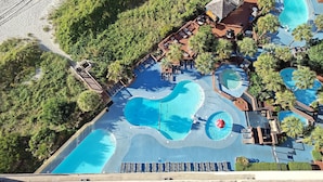 Vista aerea di un resort con diverse piscine, zone relax e una spiaggia.