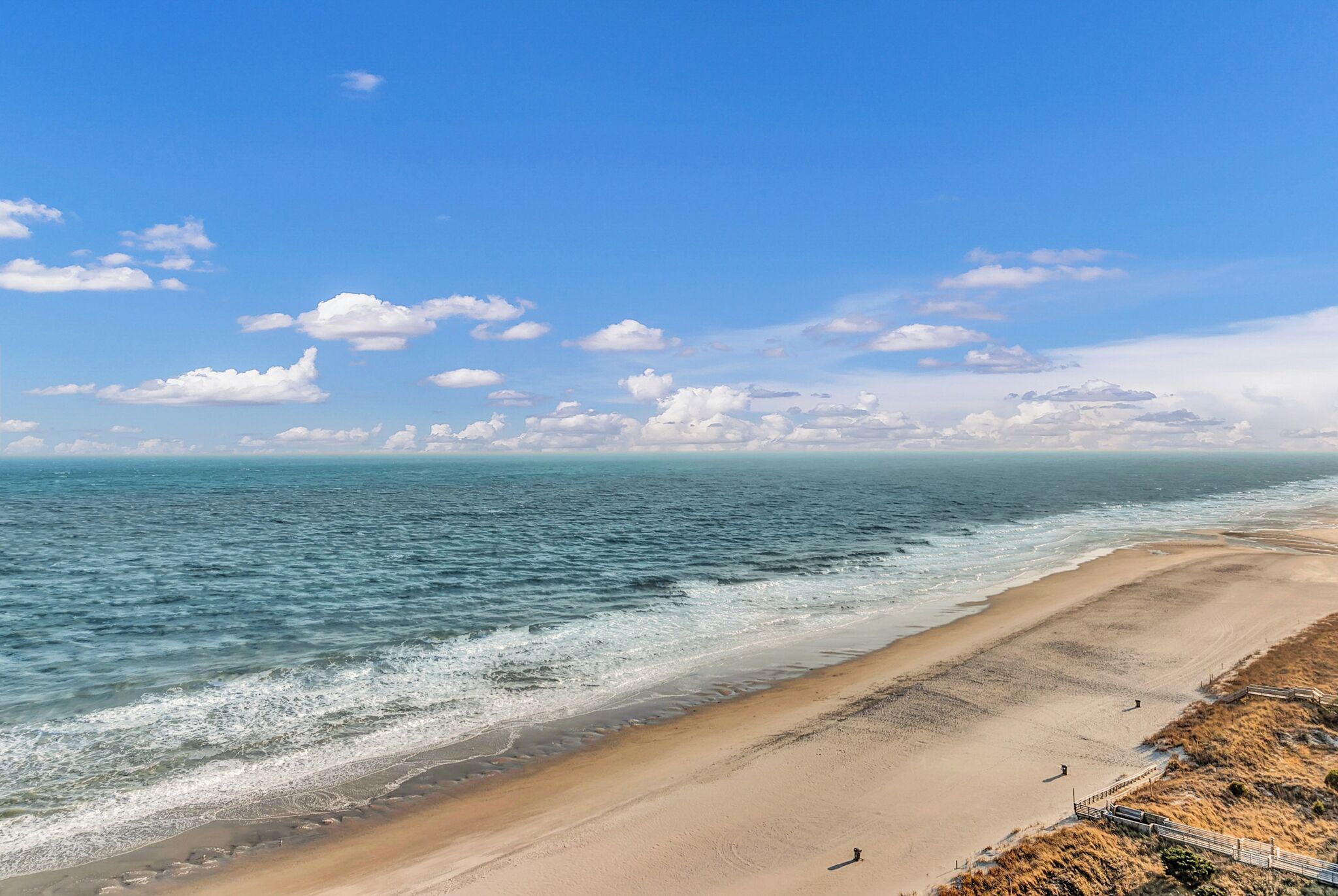 A beach with a clear sky and gentle waves.