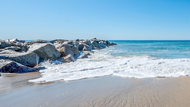 A beach with large rocks and waves. - Stunning 6-Bedroom Oceanview Vacation Home w/ Rooftop Deck (Newport Beach)