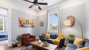 Ein Wohnzimmer mit Sofa, Sessel, Couchtisch und einem Bild an der Wand.