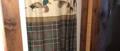 A shower curtain with a plaid pattern and duck designs.