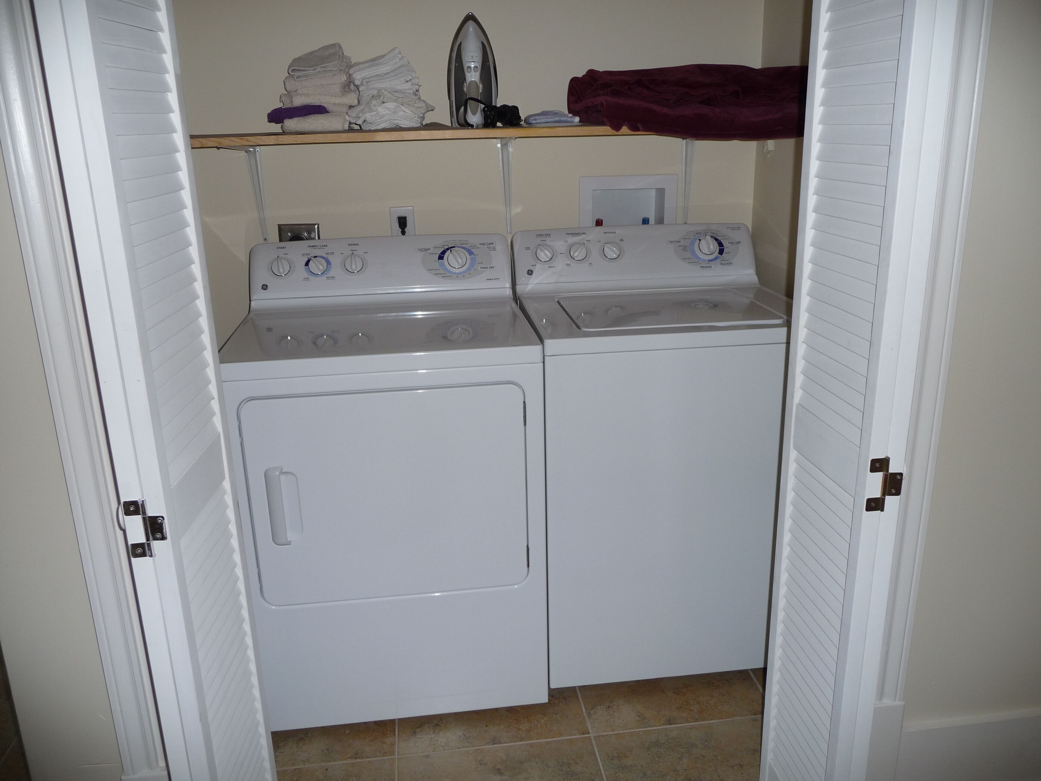 A laundry room with two washing machines and an iron.